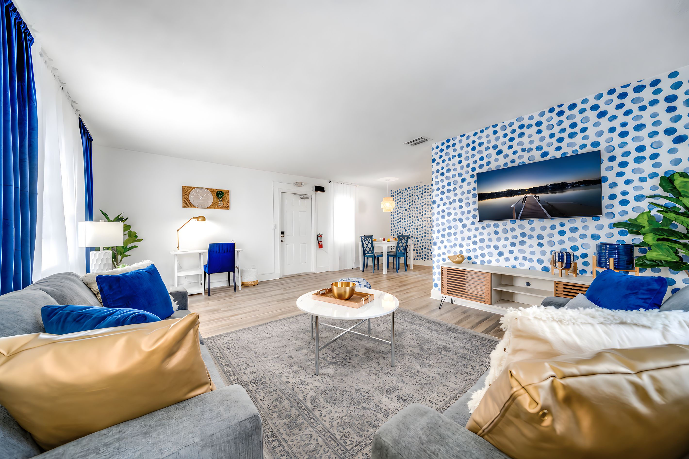 A modern living room with a sofa, coffee table, and a wall-mounted TV.