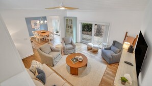 Ein großzügiger Wohnbereich mit Esstisch, Sofas und Fernseher.
