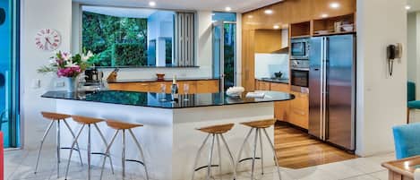 Panorama appartement | Privékeuken | Een koelkast met diepvriezer, een microgolfoven, een oven, een kookplaat