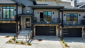 A modern two-story house with a garage, a covered porch, and a stone foundation. - Walk to Gondola: Perfect for Adventures with Private Hot Tub, BBQ & Views! (Park City)