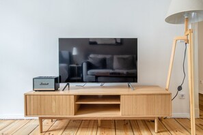 A wooden TV stand with a flat-screen TV mounted above it.