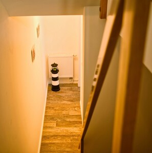 A narrow hallway with wooden flooring and a white radiator in the background. - Cozy vacation apartment near the harbor - FeWos am Hochzeitsberg FeWo 08 - FeWos (Breege)
