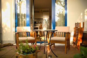 An outdoor patio with two wooden chairs, a small table, and a potted plant. - Cozy vacation apartment near the harbor - FeWos am Hochzeitsberg FeWo 08 - FeWos (Breege)