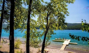 A lakeside view with a dock and trees.