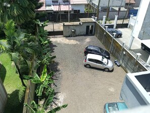 parking area with a small structure and lush green surroundings.