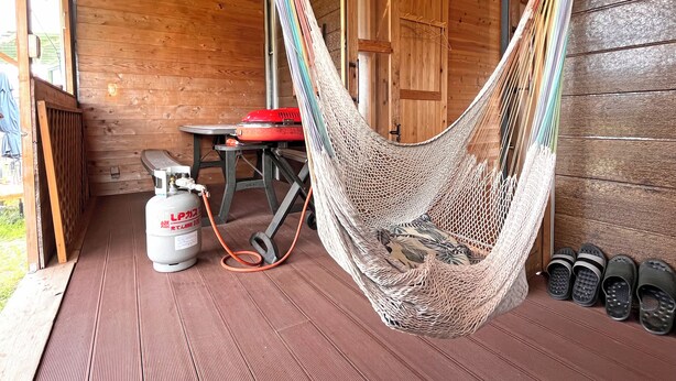A hammock in a wooden cabin with a gas stove and slippers. - Glamping Village LEAF (Mashiki)