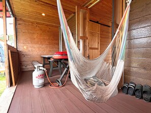 A hammock in a wooden cabin with a gas stove and slippers. - Glamping Village LEAF (Mashiki)