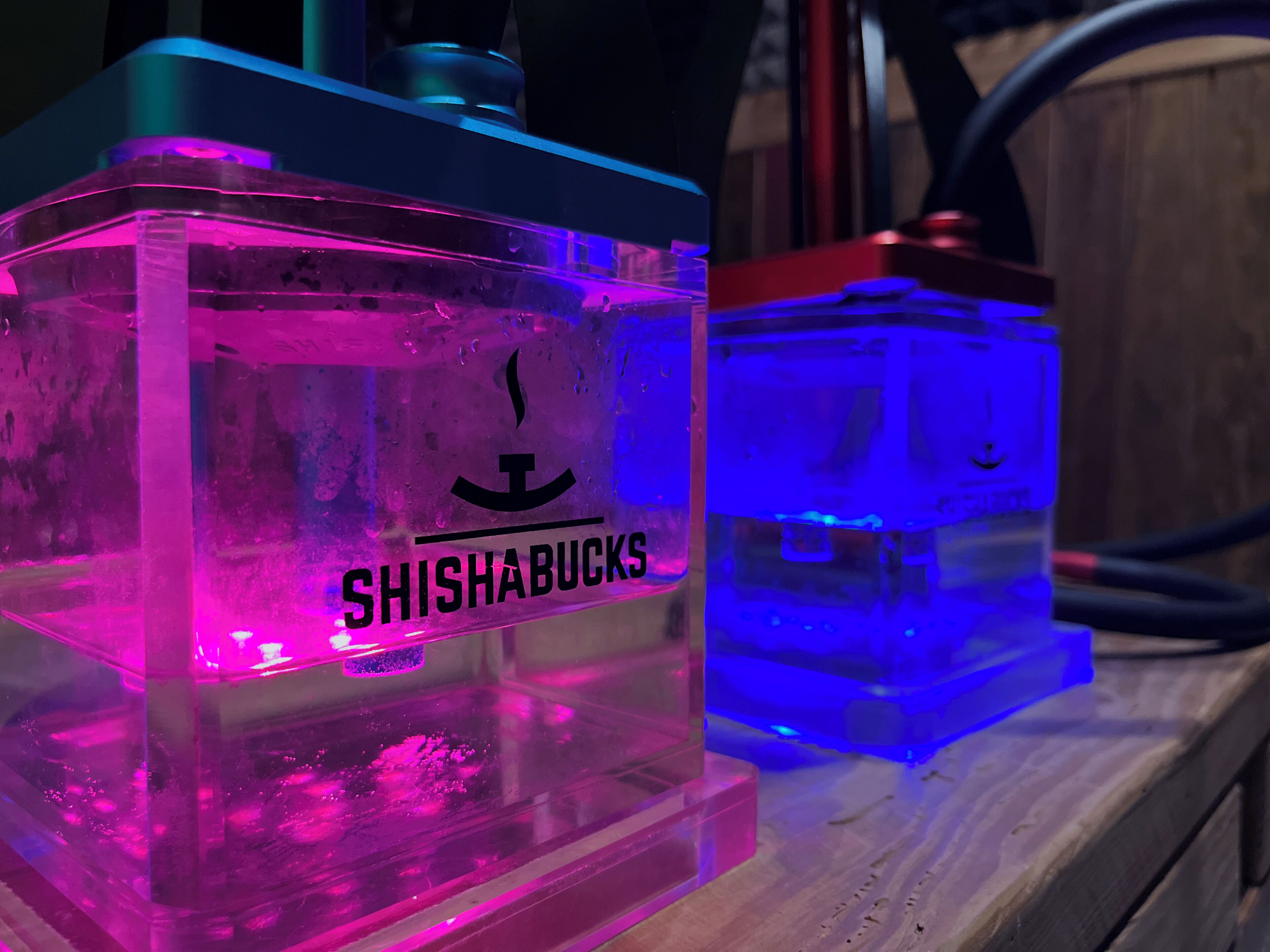 Two illuminated containers with the text 'SHISHABUCKS' on them.