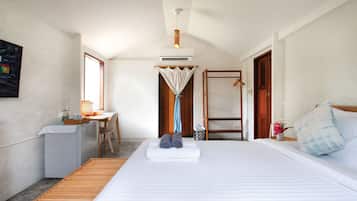 A compact hotel room with a bed, a desk, and a chair.