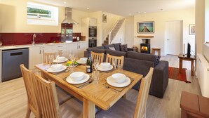 A modern kitchen with a dining area, a staircase, and a living room. - Dashel Cottage, Countisbury (Lynmouth)
