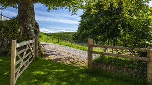A rural landscape with a dirt path, wooden gate, and lush greenery. - Dashel Cottage, Countisbury (Lynmouth)