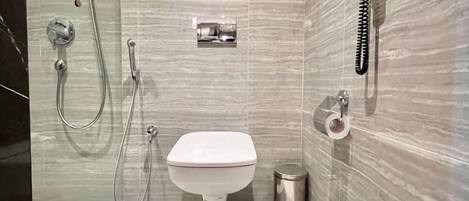 A modern bathroom with a toilet, bidet, and shower.