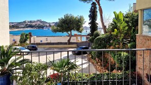 Ein Balkon mit Meerblick, ein Parkplatz und einige Grünflächen.