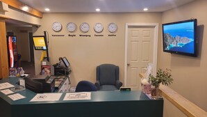 A reception desk with clocks displaying times for Vancouver, Boyle, Winnipeg, Toronto, and Halifax. - Boyle Motor Inn (Boyle)