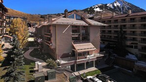 A multi-story hotel with a central atrium, balconies, and a mountain backdrop.
