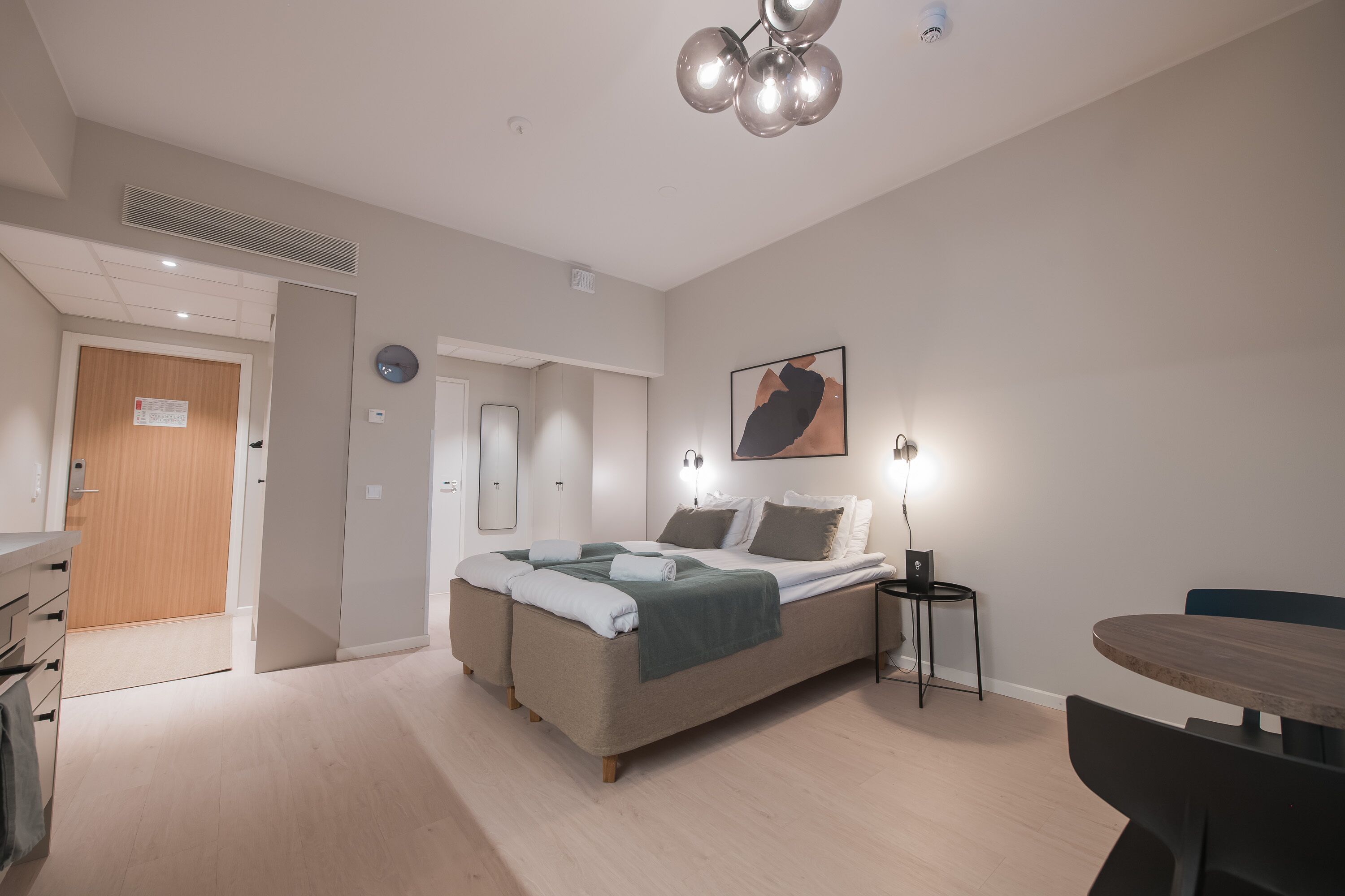 Une chambre à coucher moderne, avec un lit, une table de chevet et un bureau avec une chaise.