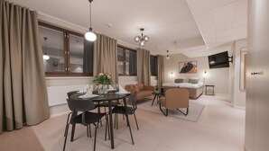 A modern living room with a dining area, a sofa, a TV mounted on the wall, and a window with curtains. - Forenom Aparthotel Tampere Kauppakatu (Tampere)