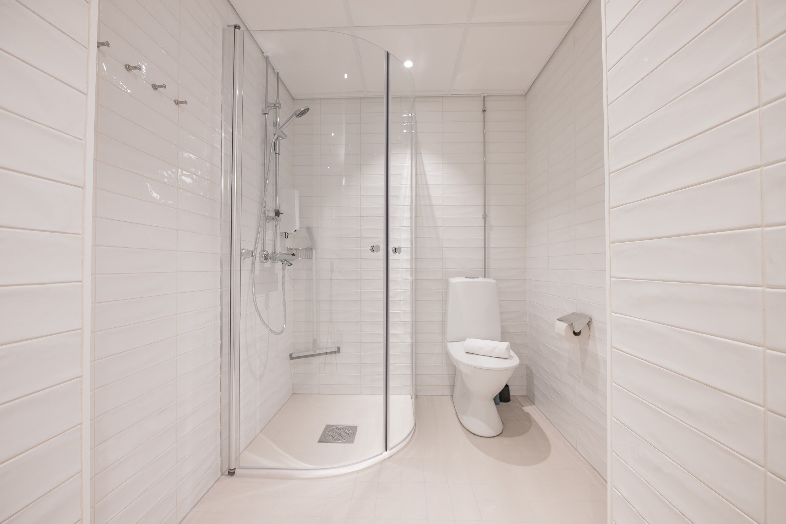 Un bagno moderno con doccia a vetro, un water e un lavandino.