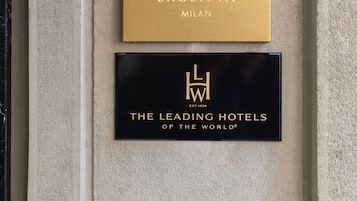 Two hotel signs: 'Casa Baglioni Milan' and 'The Leading Hotels of the World'.
