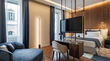 Een moderne hotelkamer met een groot bed, een bureau, een stoel, een flatscreen televisie en uitzicht op de stad door grote ramen.