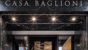 The entrance of Casa Baglioni with a marble facade, a modern chandelier, and a staircase leading inside. - Casa Baglioni Milan - The Leading Hotels of the World (Milan)
