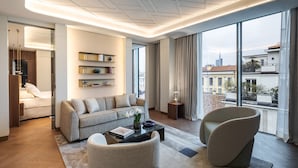 A modern living room with a sofa, armchairs, a coffee table, and a bookshelf. - Casa Baglioni Milan - The Leading Hotels of the World (Milan)