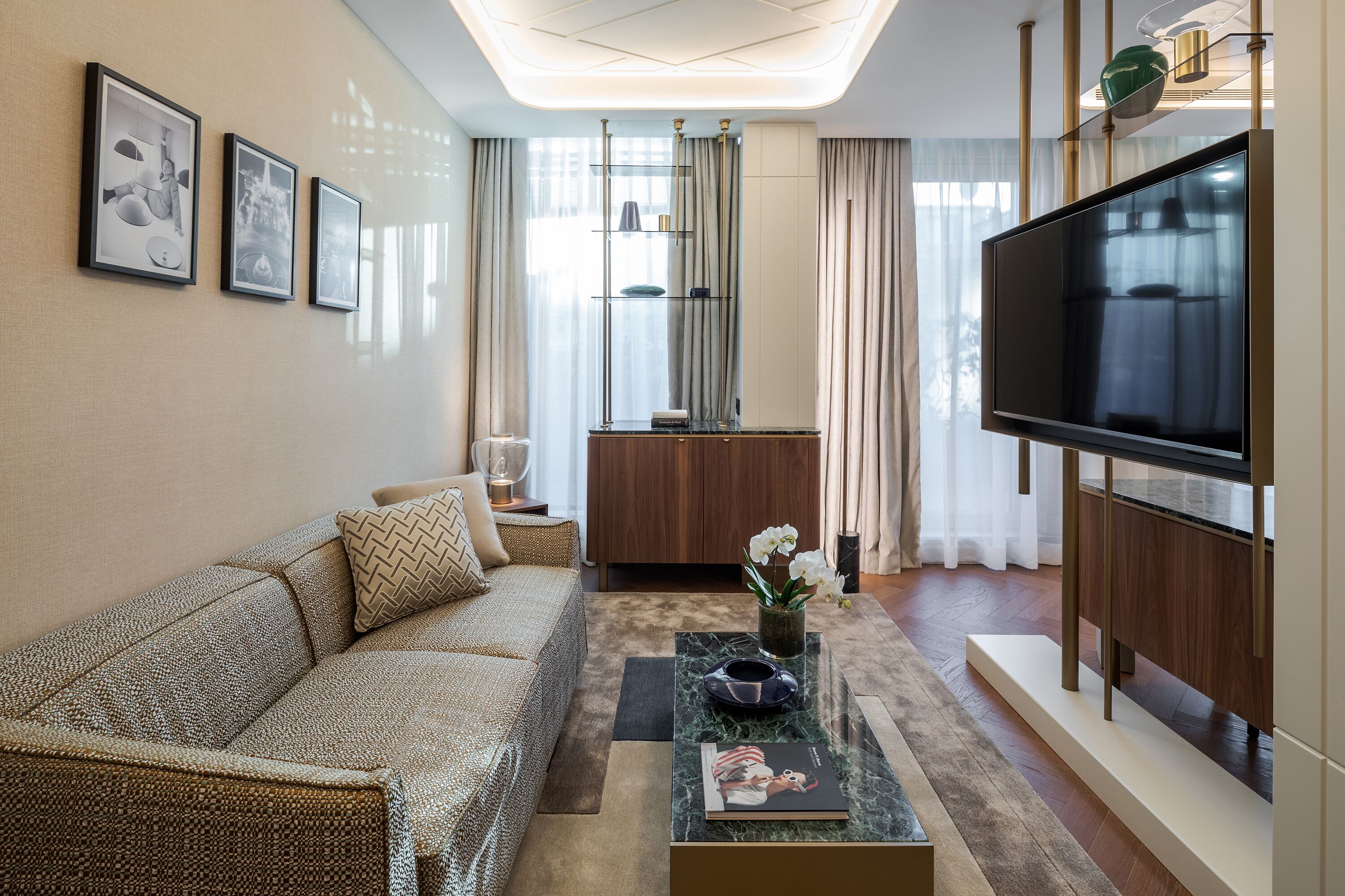 A modern living room with a sofa, coffee table, and a flat-screen TV.