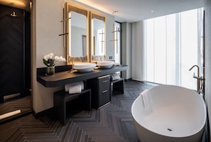A modern bathroom with two sinks, a large bathtub, and a mirror with a cross design.