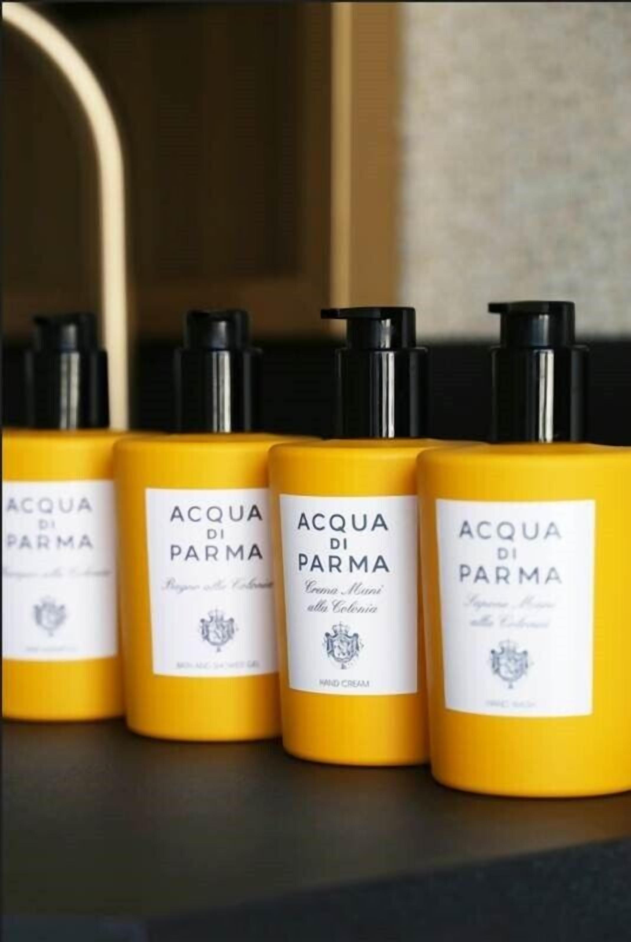 Quatro frascos de creme de mãos Acqua di Parma em uma prateleira.