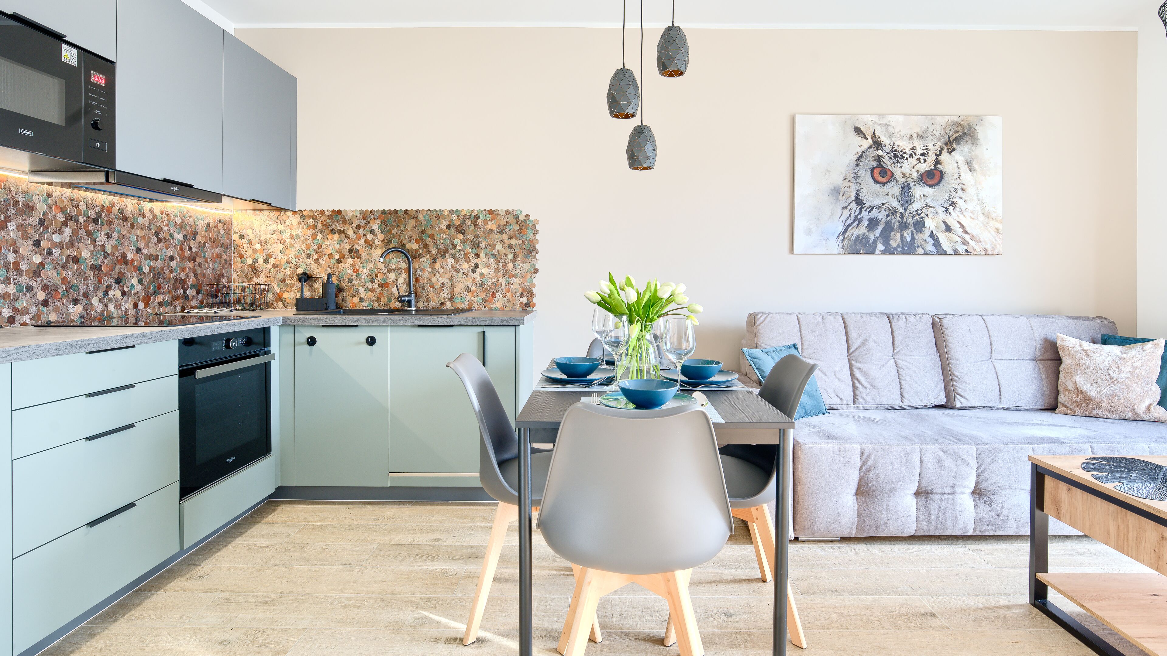 Una cucina moderna con zona pranzo, un divano e un quadro appeso al muro.