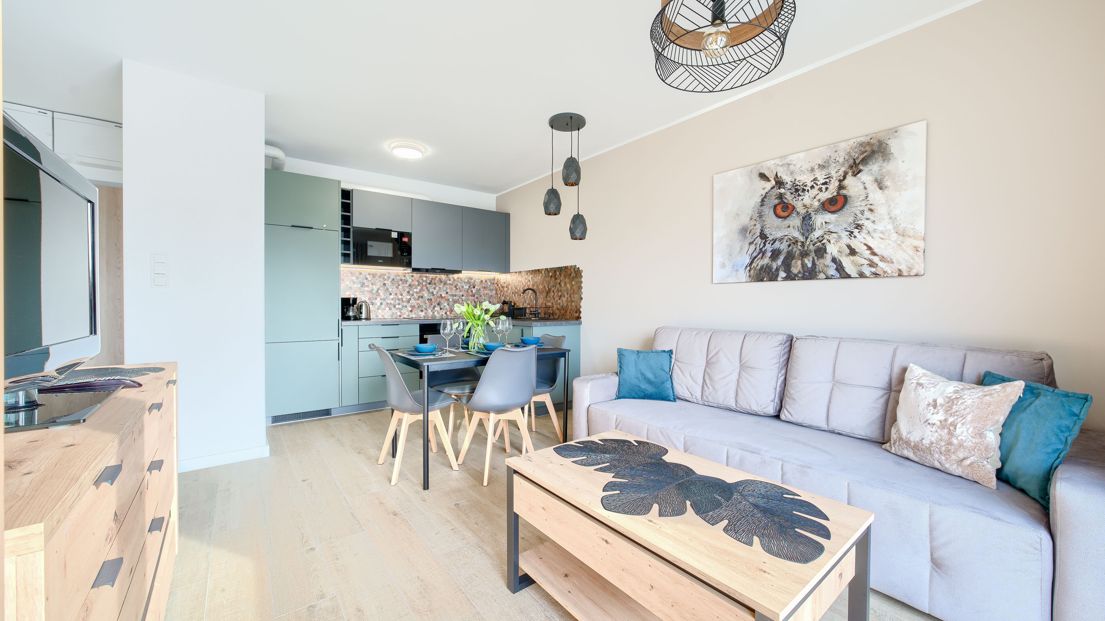 Een moderne woonkamer met een bank, een salontafel en een eethoek met stoelen en een tafel.
