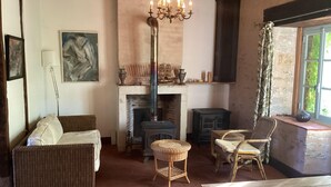 Una habitación acogedora con chimenea, muebles de mimbre y un candelabro.