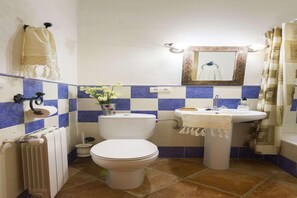 Une salle de bain équipée de toilettes, d’un lavabo et d’un radiateur.