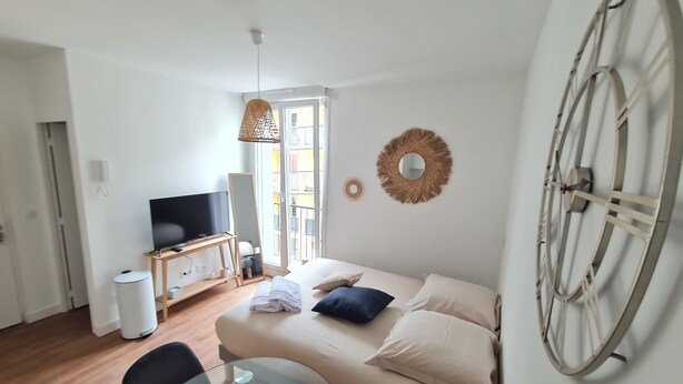 Un salon moderne avec un canapé, un téléviseur et une grande roue décorative accrochée au mur.