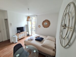 Un salon moderne avec un canapé, un téléviseur et une grande roue décorative accrochée au mur.