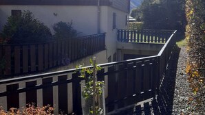 Un immeuble à plusieurs étages doté de balcons, d’un escalier et offrant une vue sur la montagne.
