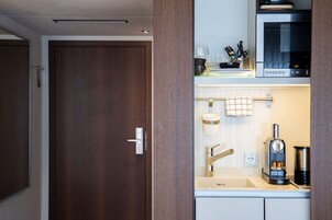 Una cocina moderna equipada con microondas, cafetera y pileta.