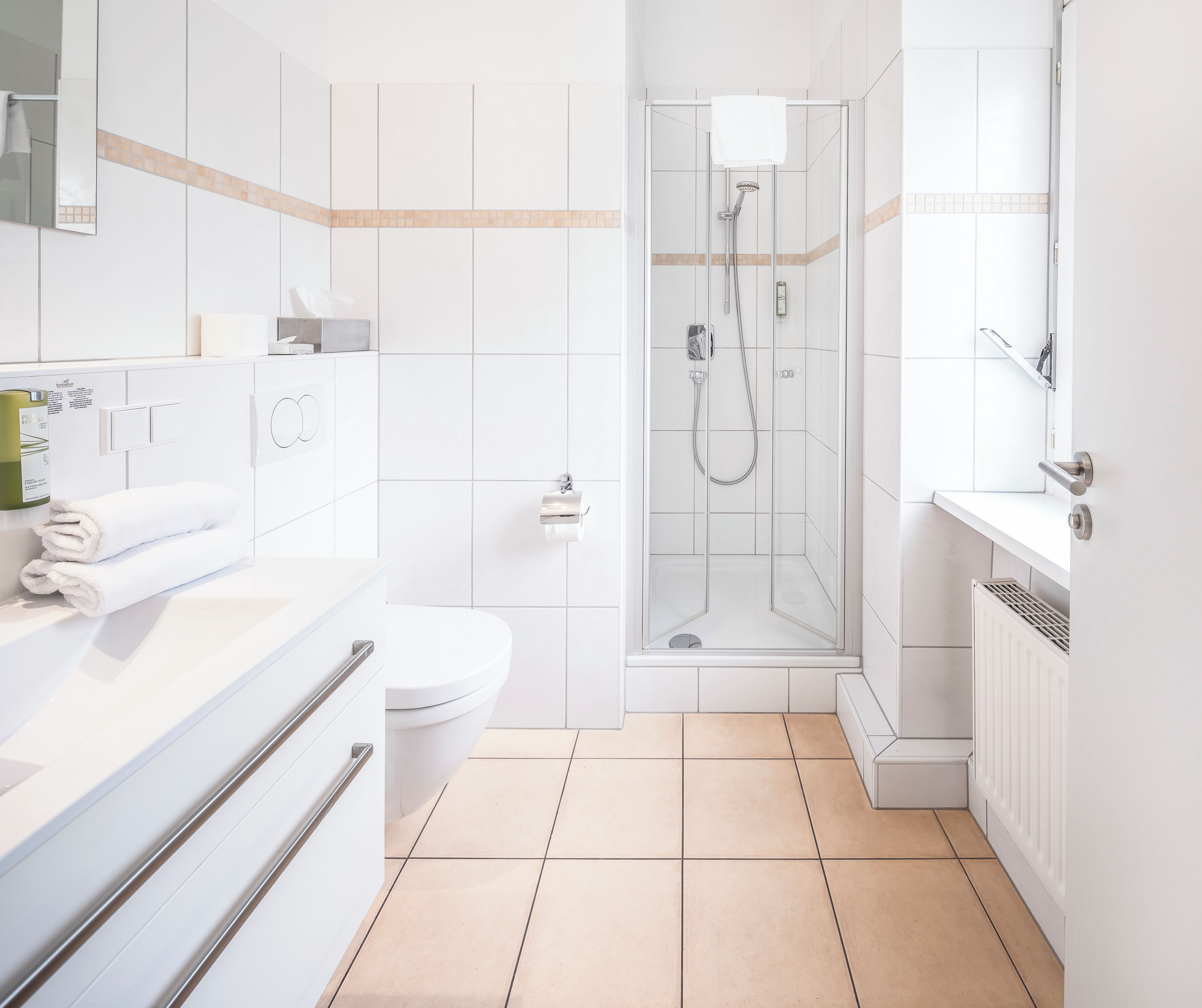 A modern bathroom with a toilet, sink, and shower area.