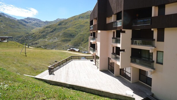 A modern multi-story building with balconies, set against a mountainous backdrop. - Ski-in/Ski-out Apartment in Reberty 1850, Les Menuires - Sleeps 4, 1 Bed, 1 Bath (Les Menuires)