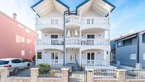 A multi-story building with a symmetrical facade, balconies on each floor, and a gated entrance. - Amazing apartment in Biograd na Moru with WiFi (Biograd na Moru)