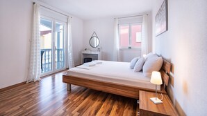A bedroom with a wooden bed, a bedside table with a lamp, a round mirror, and a desk with a chair. - Amazing apartment in Biograd na Moru with WiFi (Biograd na Moru)