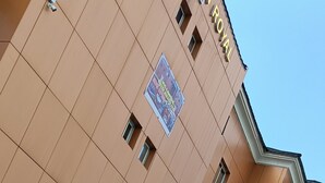 Un hôtel doté d’un espace piscine, comprenant une piscine aux carreaux bleus et un escalier métallique pour y accéder.