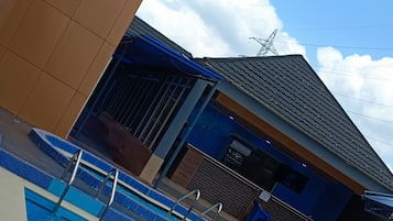 Una piscina al aire libre, sombrillas, socorrista en las instalaciones