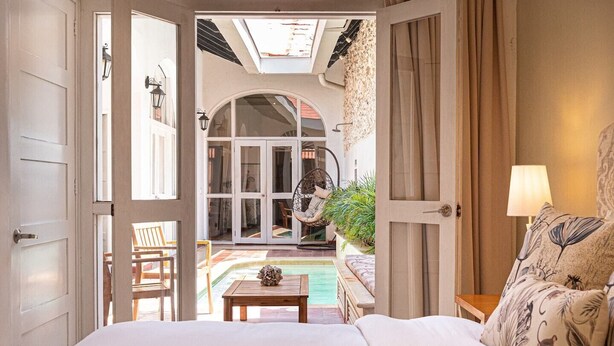 Ein Schlafzimmer mit Blick auf einen Pool und eine Außen-Sitzgelegenheit.