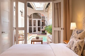 Un dormitorio con vistas a una piscina y zona de estar al aire libre.
