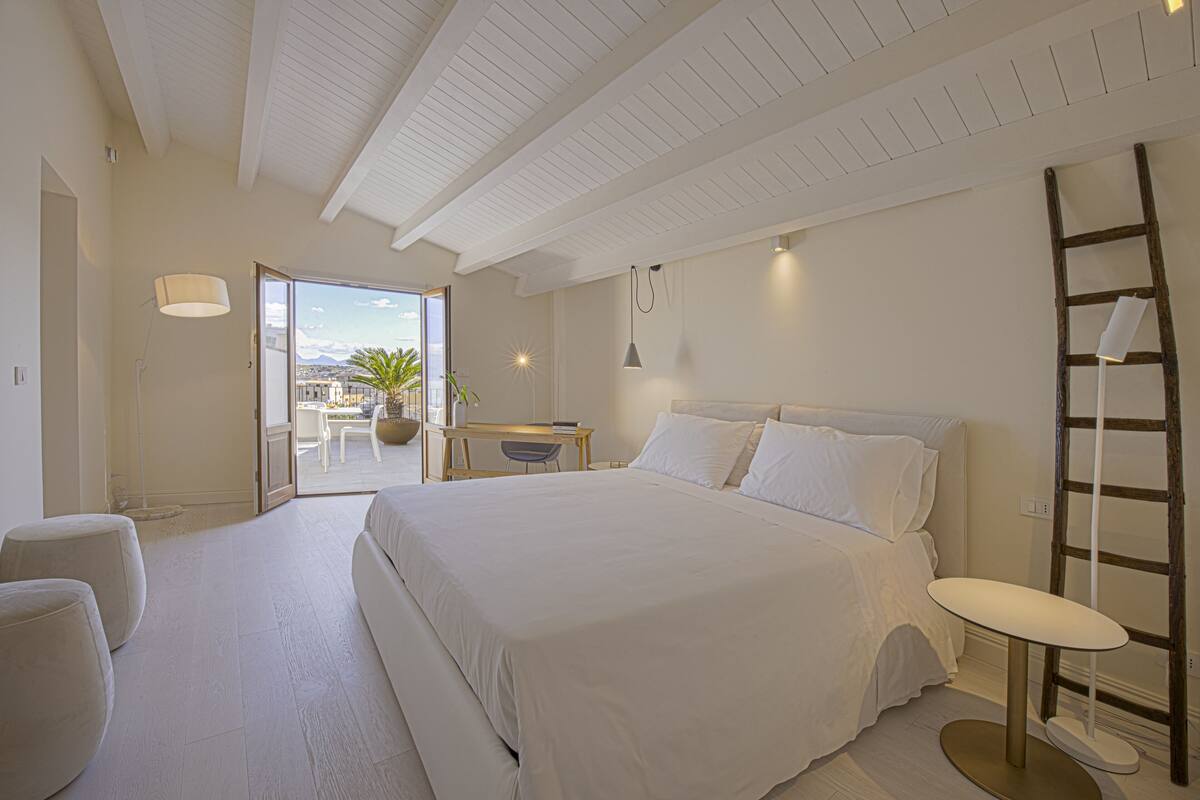 Une chambre spacieuse avec un grand lit, un bureau et une vue sur l’extérieur.