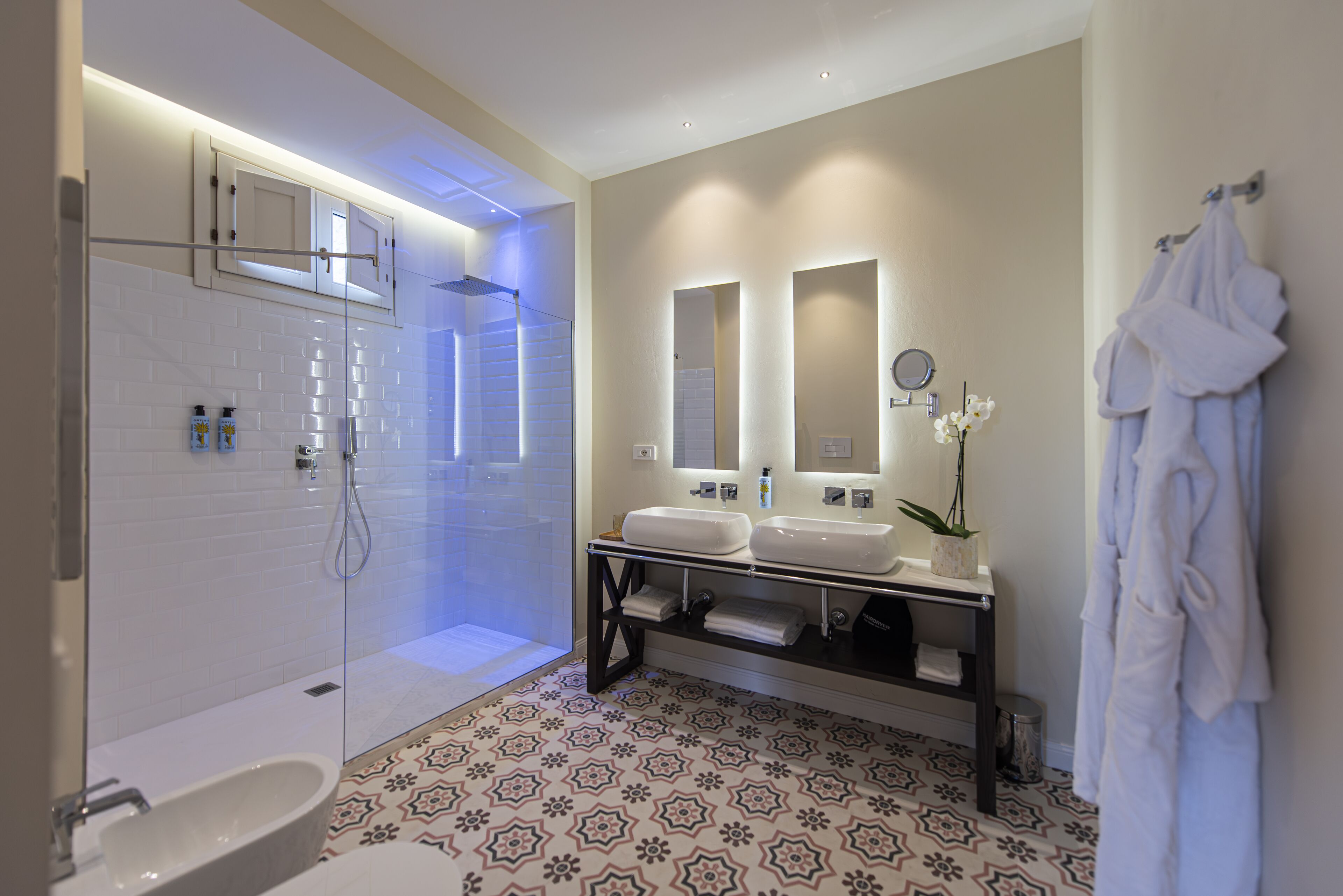 A modern bathroom with a bathtub, two sinks, and a vanity.