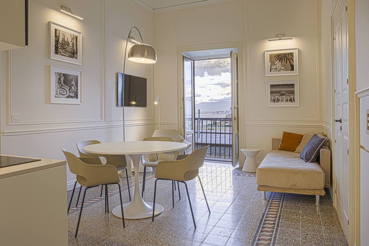Une chambre moderne dotée d’un coin repas, d’un canapé et d’un balcon offrant une vue sur la ville.