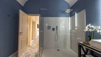Une salle de bain moderne avec une douche à parois de verre, un lavabo blanc et un carrelage décoratif.