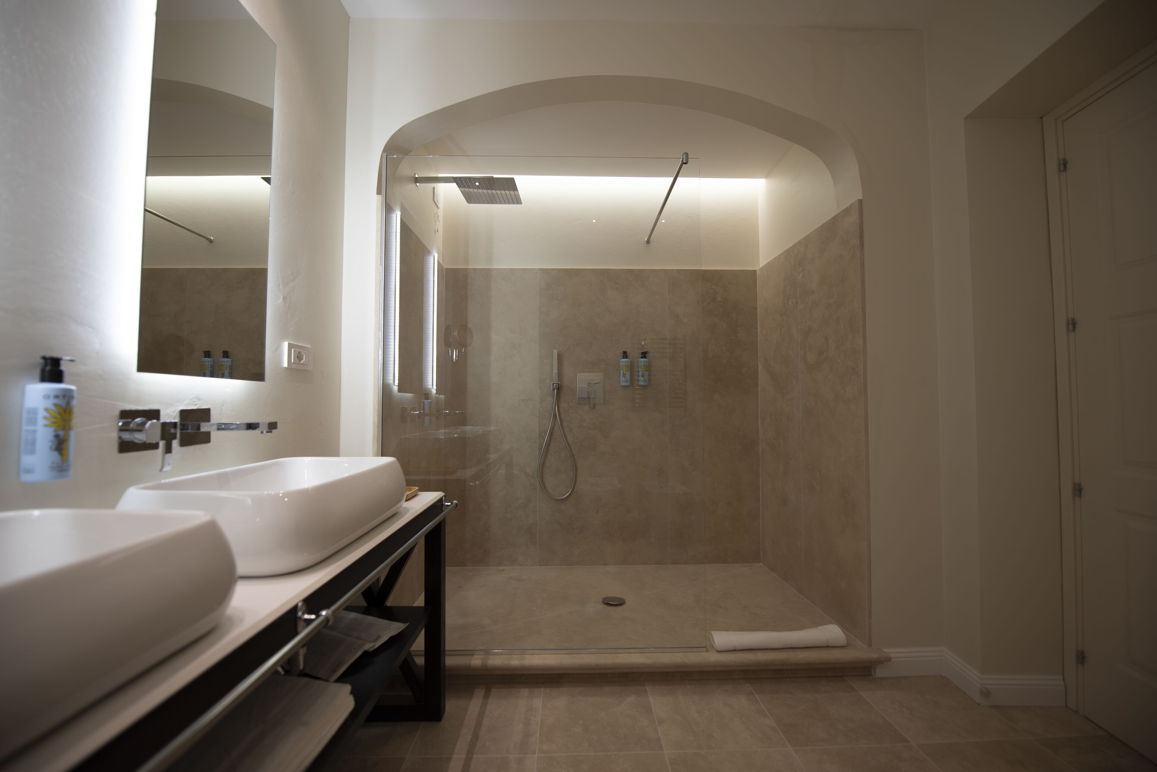 Ein modernes Badezimmer mit zwei Waschbecken, einer Dusche und einer Duschkabine.